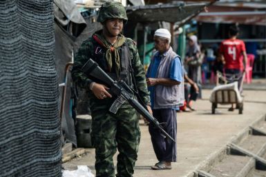 A Thai soldier patrols the Tak Bai riverside market on Friday's anniversary