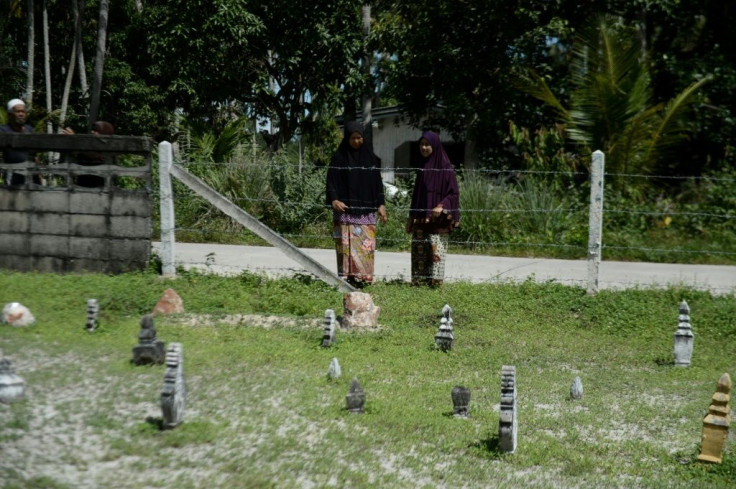 Women visit a cemetery in Tak Bai where protesters who died during the 2004 anti-government protests are buried