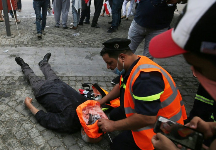 A member of the Iraqi rescue teams gives first aid to a protester with breathing difficulties, in the second wave of protests after 150 people were killed earlier this month