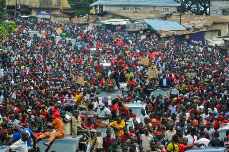 Guineans wearing red in honour of those killed during demonstrations take part in a protest against the third term of the Guinean President, on October 24, 2019 in Conakry.Crowds of protesters marched through the Guinean capital of Conakry on October 24 i