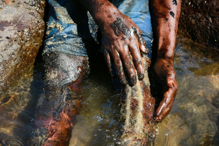 A boy cleans oil from his leg after the spill in Pernambuco state