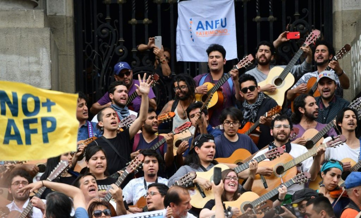 Demonstrators play the guitar performing Chilean musician Victor Jara's "The Right to Live in Peace" in Santiago, on October 25