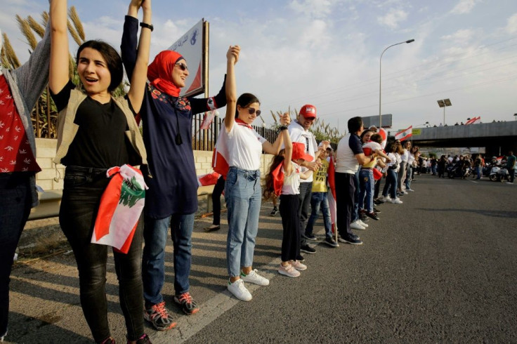 Lebanese protesters hold hands to form an unbroken human chain running the entire length of the country from north to south as a symbol of unity, during ongoing anti-government demonstrations on Sunday