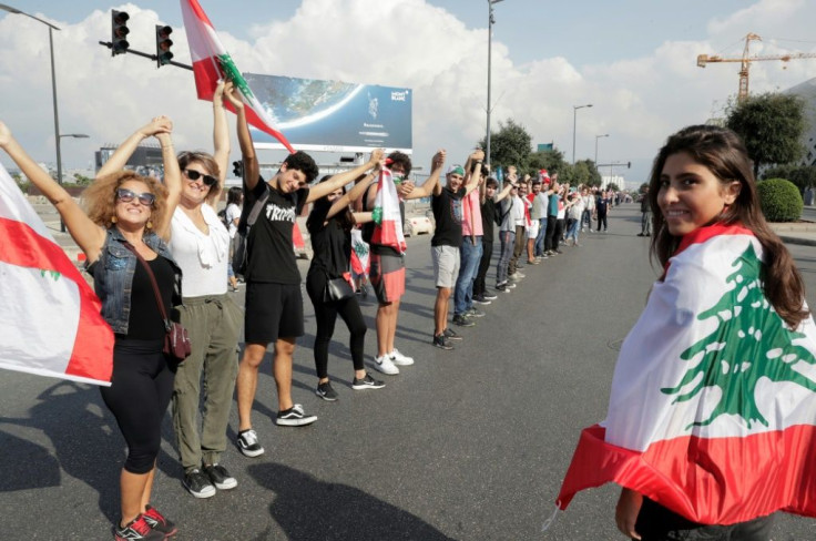 Lebanese protesters hold hands to form a human chain