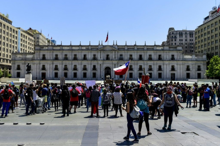 Demonstrators outside the Presidential Palace, known as La Moneda, in Santiago, Chile where President Sebastian Pinera shuffled his cabinet amid a crisis