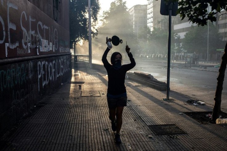 A woman bangs on a pot during protests in Santiago on October 29, 2019