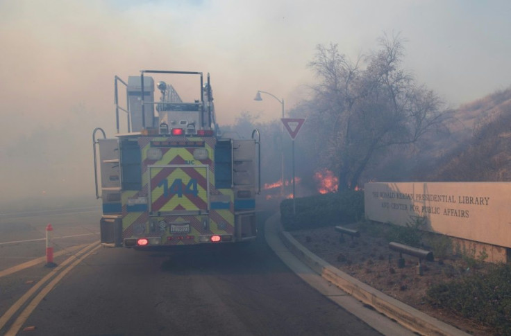 Flames cross the driveway of the Reagan Presidential Library as firefighters battle to protect it from the Easy Fire in Simi Valley, California on October 30, 2019