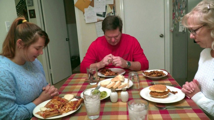 In this still image taken from video, autoworker Mike Yakim prays with his wife Sara and their niece, Haley (L), before dinner on October 16, 2019, in Lordstown, Ohio, where US President Donald Trump garnered unexpected support in 2016