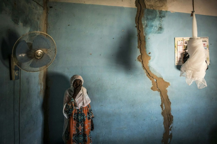 Khady, who lives on the outskirts of the forest, stands next to cracks in her walls caused by explosions from the quarry