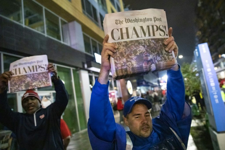 Fans celebrate the Nationals victory with early editions of the Washington Post