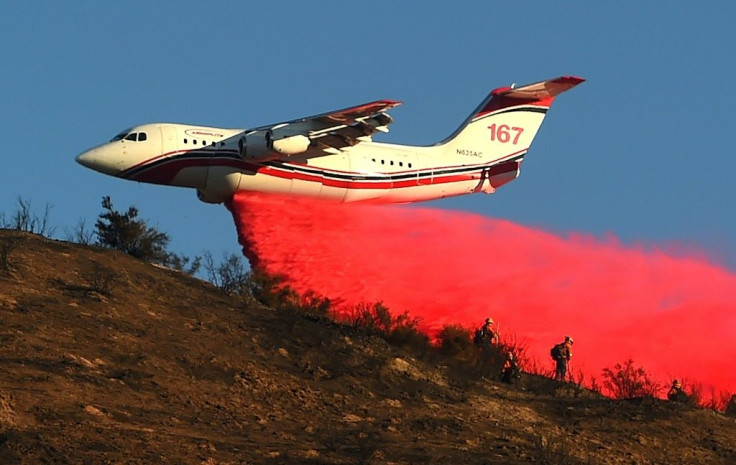 An air tanker drops fire retardant over power lines while helping to fight the Hillside Fire in the North Park neighborhood of San Bernardino, California on October 31, 2019.