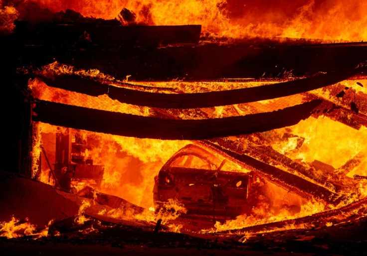 A car burns in a garage as a home goes up in flames during the Hillside fire in the North Park neighborhood of San Bernardino, California on October 31, 2019.