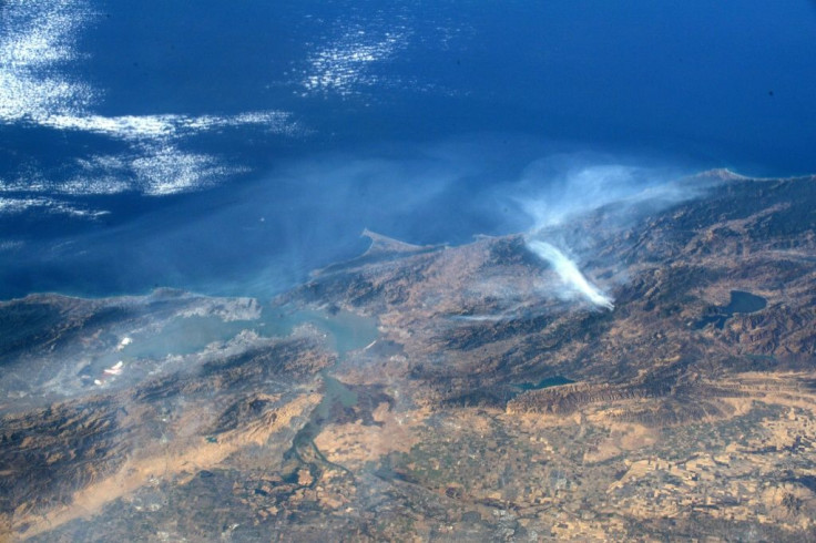 This undated handout image courtesy of NASA and taken by astronaut Andrew Morgan aboard the International Space Station, shows smoke from the Kincade Fire (R) in Sonoma County, northern California.