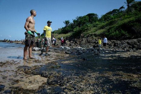 The oil has been seen along Brazil's northeastern Atlantic coast, including Pernambuco state, where volunteers are pictured cleaning up on October 21, 2019