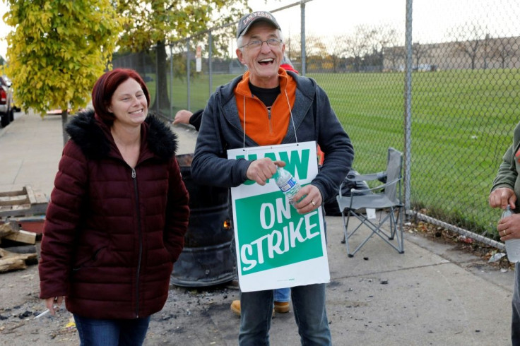 United Auto Workers (UAW) members Melissa Rose-Gorney and Nelson Worley, standing outside the GM Detroit-Hamtramck Assembly plant in Detroit, Michigan, react after reading the news that their contact with General Motors was ratified