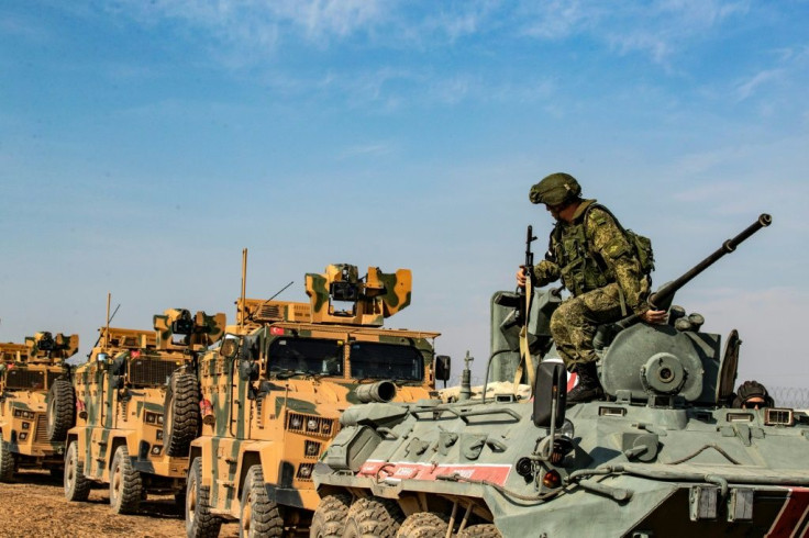 Turkish and Russian military vehicles carry out a joint patrol in the Syrian town of Derbasiyeh