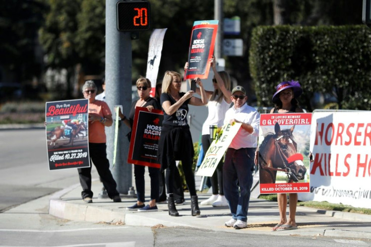 Protesters hold signs against horse racing in front of Santa Anita Park, where the $28 million Breeders' Cup kicked off with five races on Friday