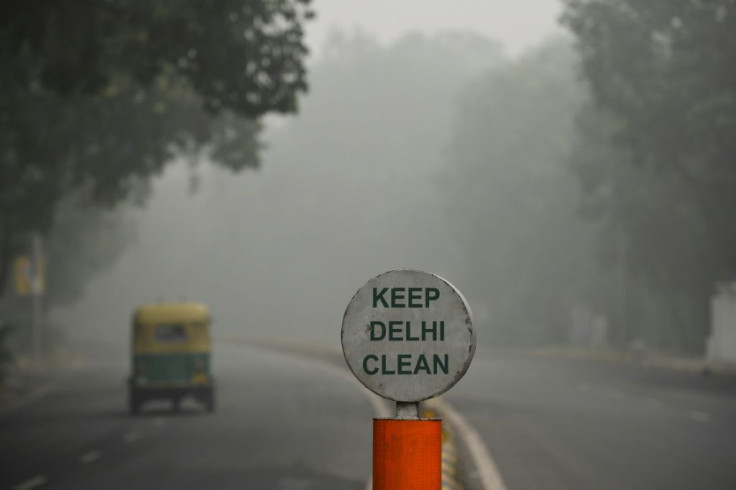 A rickshaw drives along a road under heavy smog conditions in New Delhi