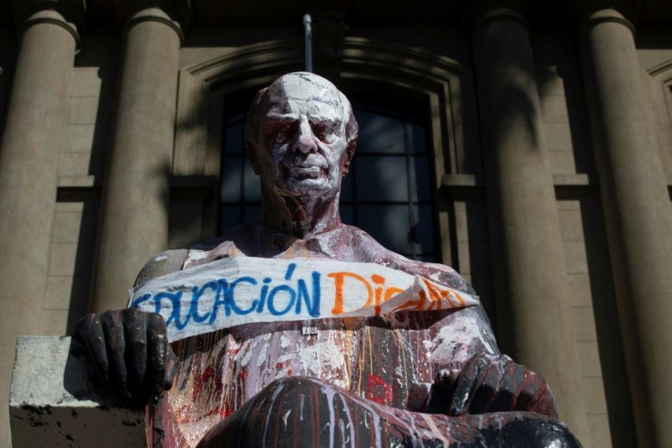 View of a vandalized statue with a banner reading "Dignified education" during protests against the Chilean government on October 29, 2019