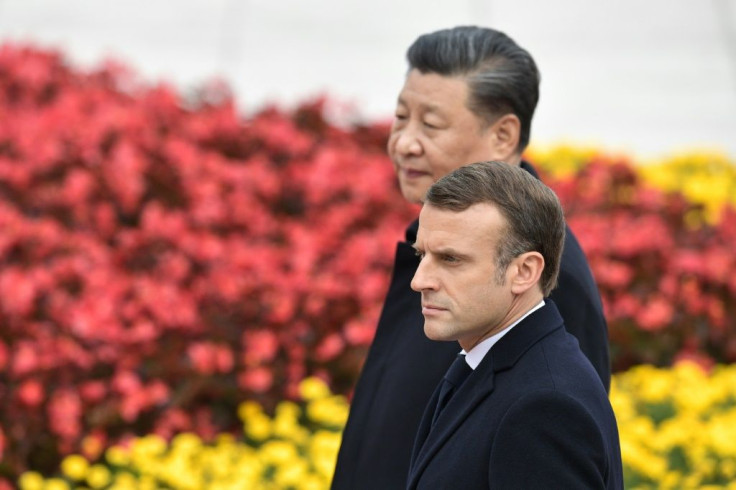 French President Emmanuel Macron walks with Chinese President Xi Jinping during a welcome ceremony at the Great Hall of the People in Beijing