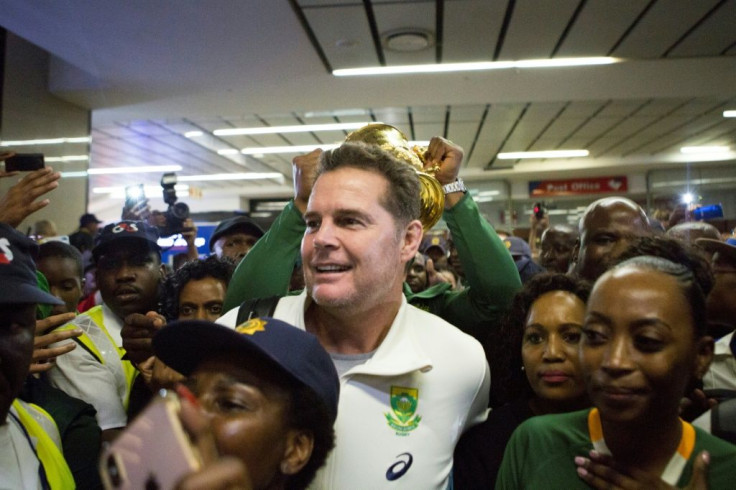 Springboks coach Rassie Erasmus (C) surrounded by Springbok supporters at OR Tambo airport near Johannesburg this week after arriving from Japan
