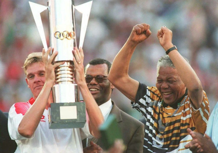 Then South Africa president Nelson Mandela (R) celebrates as captain Neil Tovey (L) holds the Africa Cup of Nations trophy after defeating Tunisia in the 1996 final