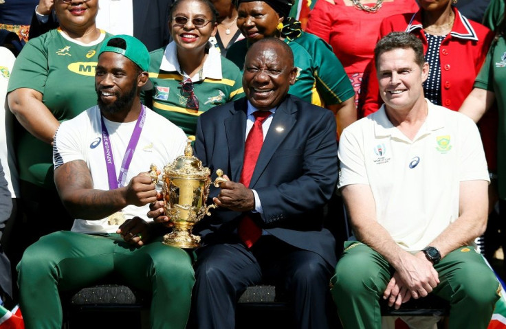 South African President Cyril Ramaphosa holds the Rugby World Cup trophy with Springboks captain Siya Kolisi
