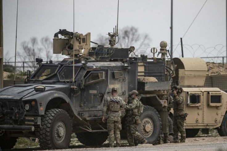 US troops gather around their military vehicles near Omar oil field in eastern Syria's Deir Ezzor province on March 23, 2019