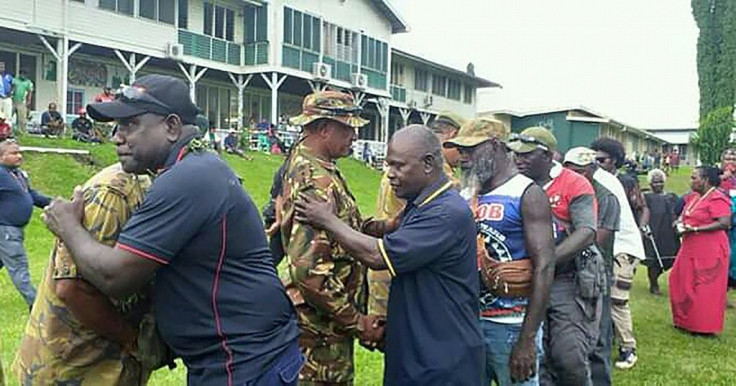 Former Bougainville Revolutionary Army fighters embrace Papua New Guinean policemen at a reconciliation ceremony in Kokopo in East New Britain