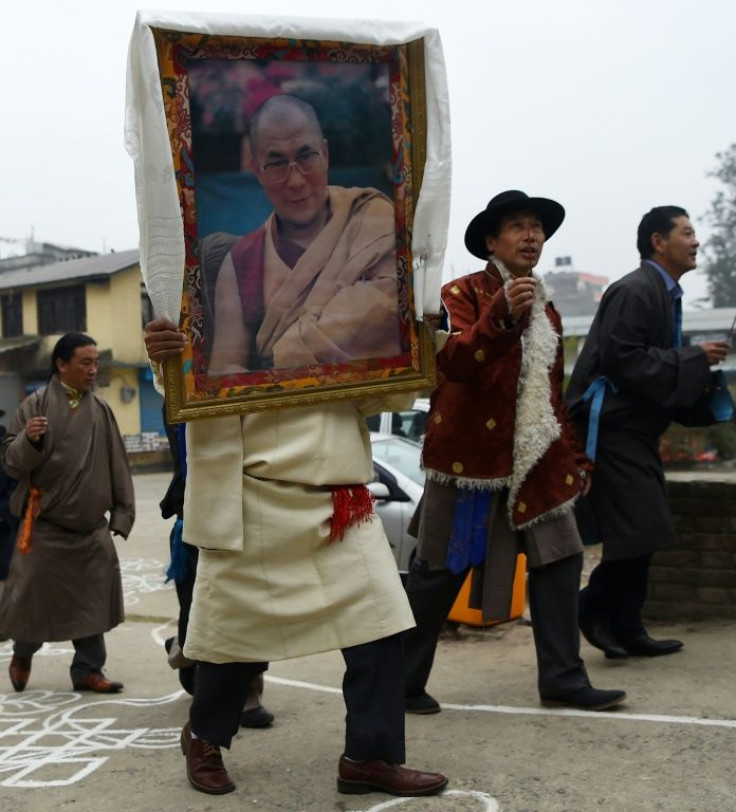 A Tibetan-in-exile carries a photograph of the Dalai Lama during celebrations marking the Lunar New Year in Kathmandu in February 2018