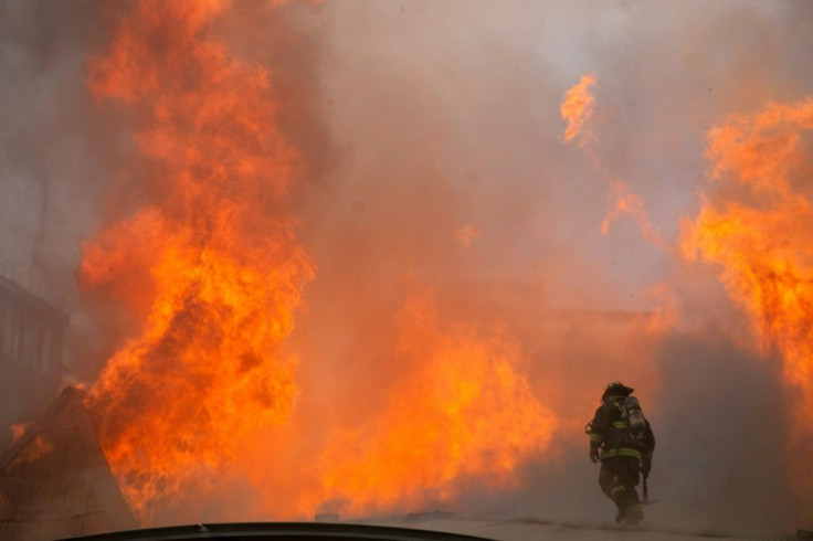 Firefighters work to extinguish a fire at Pedro de Valdivia University following a protest against the government of Chilean President Sebastian Pinera in Santiago, on November 8, 2019