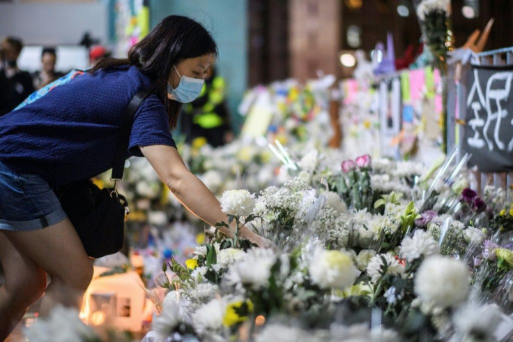 Mourners pay their respects at the site where a student fell to his death during a recent protest