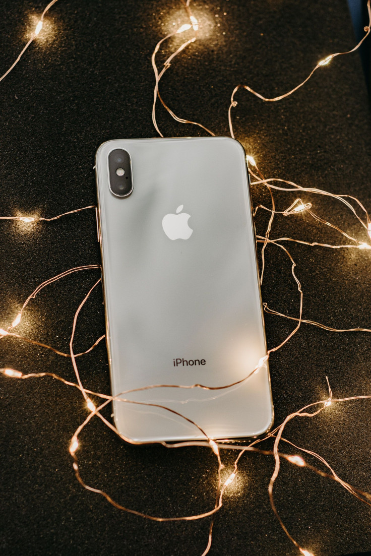 silver-iphone-x-lying-on-pre-lit-string-lights-1647976