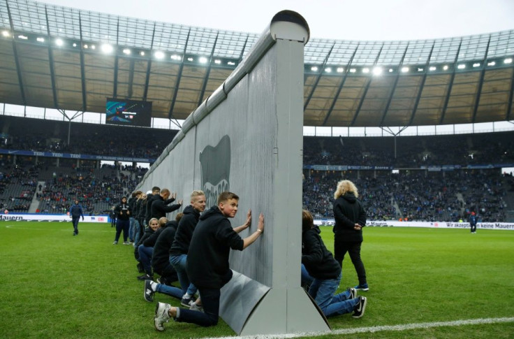 Volunteers prepare to knock down a mock-up of the former Berlin Wall bearing the inscription "Against Walls together with Berlin", before the Bundesliga match between Hertha Berlin and RB Leipzig on Saturday.