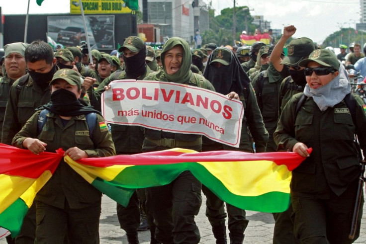 Police officers in Santa Cruz, Bolivia, have joined  anti-government protests; they are seen marching on November 9, 2019, carrying a banner that reads 'Bolivians more united than ever'