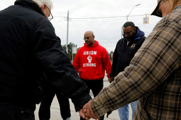 United Auto Workers (UAW) member Joe Ryan (C) leads a prayer circle to recite a strike closing prayer last month as General Motors workers voted to ratify a new contract