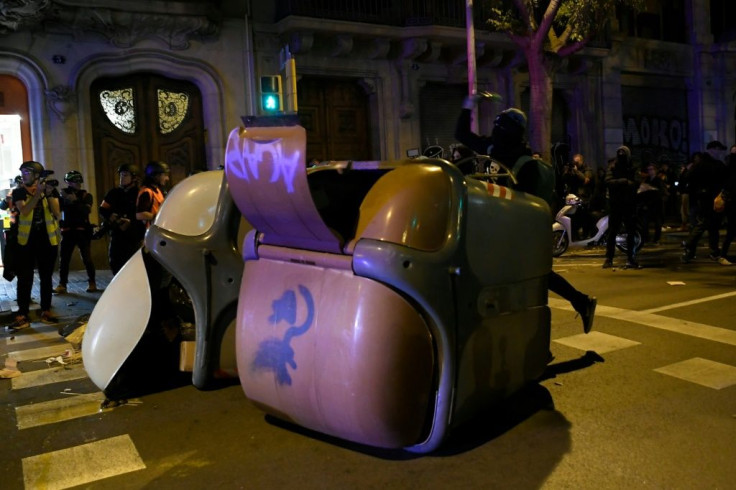 Protesters throw objects during a demonstration in Barcelona on the even of Sunday's election, amid heightened tensions over the Catalan crisis