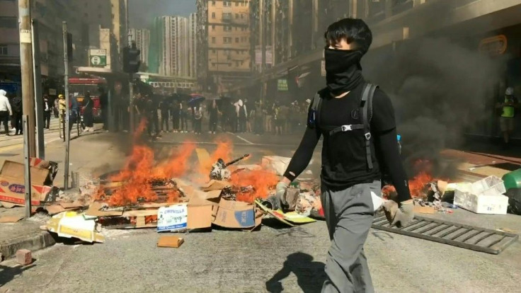 IMAGESFlashmob protests spring up in multiple Hong Kong districts during the morning commuter period, with small groups of masked protesters building barricades on road junctions.