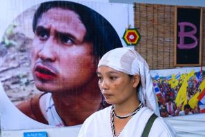Pinnapha Phrueksapan, widow of ethnic Karen leader "Billy" Por Cha Lee Rakcharoen, stands beside his portrait following a ceremony in Bangkok in September 2019
