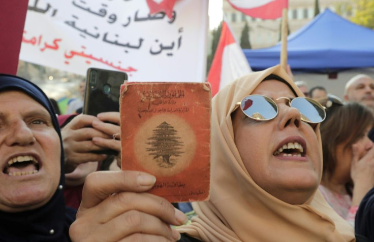 A Lebanese demonstrator holds up an old identity card during a march organised by the "My Nationality, My Dignity" campaign in Beirut