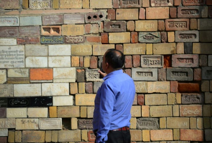 A Hindu devotee examines bricks for the proposed temple