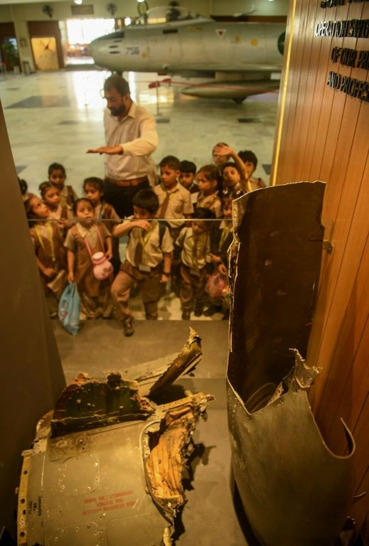 Pakistan students look at parts of the wreckage of an Indian Mig-21 being flown by Indian pilot, Abhinandan Varthaman when he was shot down over Kashmir