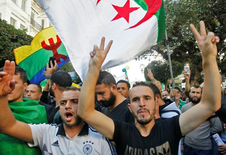 Algerian protesters, with the Berber flag in the background, chant slogans during anti-government demonstrations in the capital Algiers