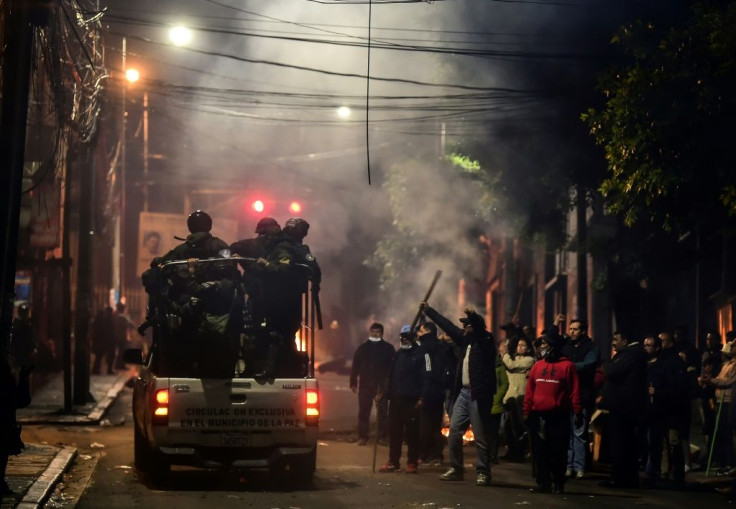 People gesture at policemen in La Paz, Bolivia on November 11, 2019 after president Evo Morales announced his resignation