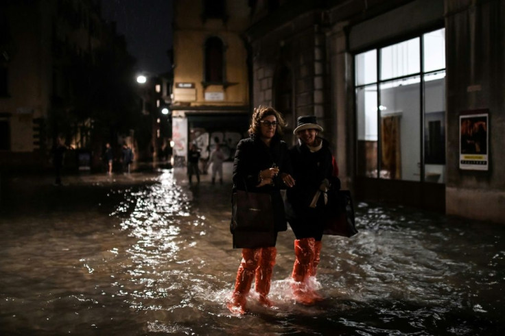 People cross a flooded street during an exceptional "acqua alta" on November 12 in Venice