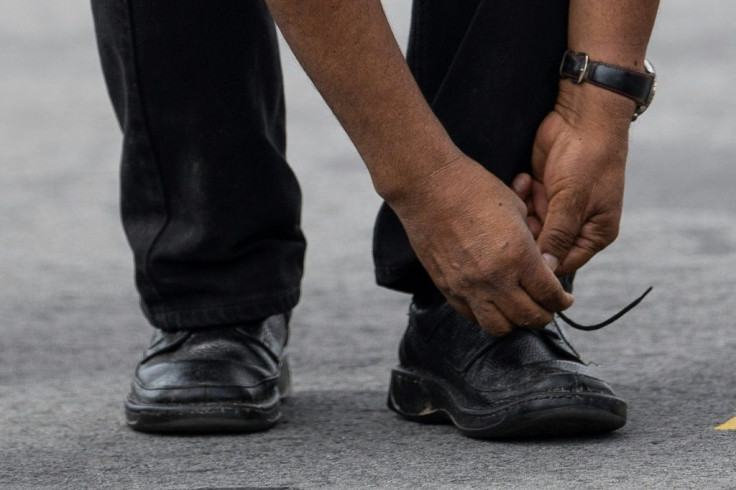 Bolivian ex-President Evo Morales ties his shoe upon landing in Mexico City, on November 12, 2019, where he was granted asylum after his resignation