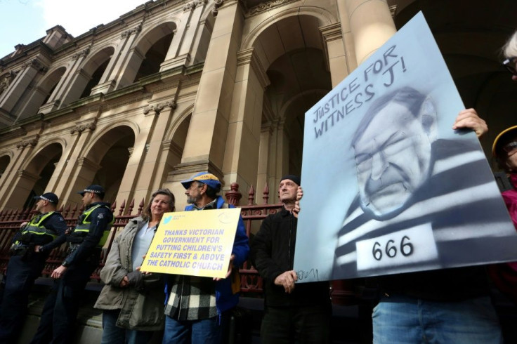 Protestors hold placards outside the court building as Australian Cardinal George Pell is escorted into the Supreme Court of Victoria in Melbourne on August 21, 2019.