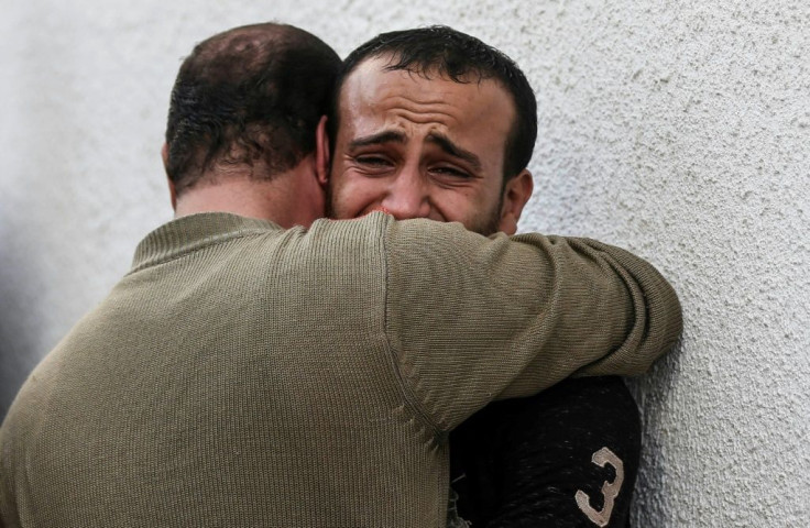 Palestinian men mourn outside the mortuary of Al-Shifa hospital in Gaza City as the death toll from Israeli strikes tops 20