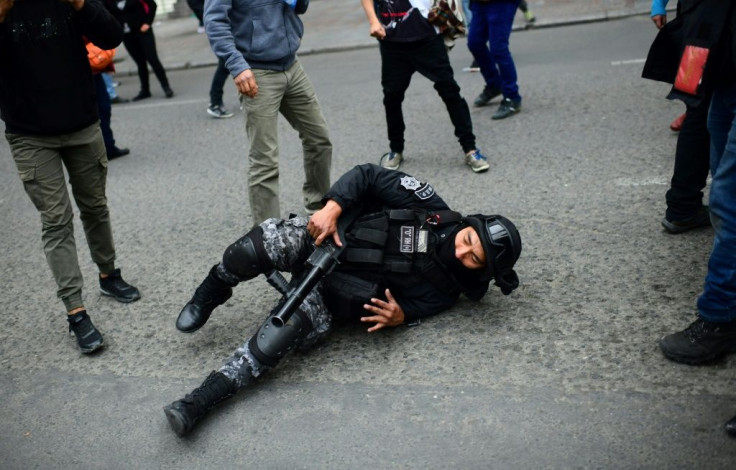 A riot policeman lies on the ground during clashes with Morales supporters in La Paz Wednesday