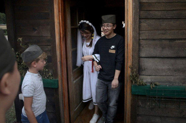 Chinese tourists are led through Serbian wedding traditions, such as shooting an apple, riding up a hillside in a horse-drawn carriage and "bargaining" a price for the bride